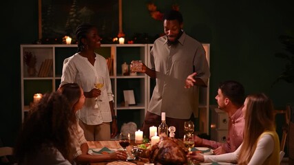 Friends giving thanks and toasting at thanksgiving dinner - Powered by Adobe