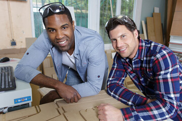 portrait of two male carpenters in woodwork workshop