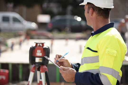 surveyor on site writing on clipboard