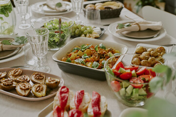 Assorted fresh vegetable dishes, salads, roasted potatoes, stuffed mushrooms, and sliced bread with...