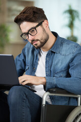 young disable man using laptop and working from home