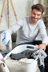 happy husband man doing laundry at home