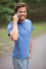 portrait of cheerful mature man using mobilephone and laughing