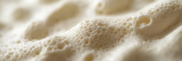 Fototapeta premium Bubbling foam of freshly made batter captured in close detail during a baking session in a cozy kitchen