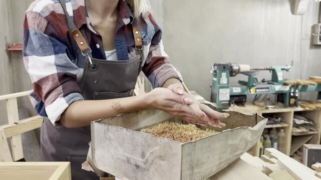 Woodworking Dust: A close-up of a woodworker's hands sifting through fine wood shavings in a workshop, emphasizing the tactile nature of the craft.