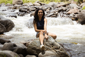 Female Traveler Exploring and Relaxing by a Rocky River