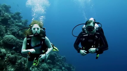 Two scuba divers posing for the camera during an exciting underwater exploration of a coral reef