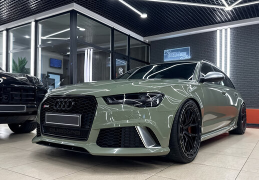 A green Audi RS6 Avant touring car in showroom, luxury car exterior. The modern exterior of a premium Germany car Audi RS6 Avant (C7) pistachio color. VAG car. 