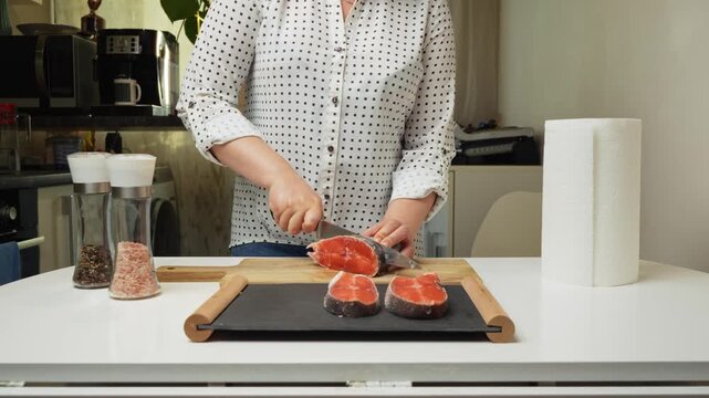 Female hands preparing the trout fish for cooking at home kitchen. Concepts of healthy eating and seafood