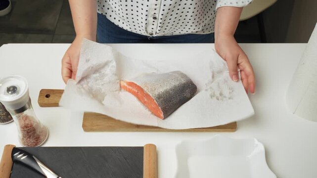 Female hands preparing the trout fish for cooking at home kitchen. Concepts of healthy eating and seafood