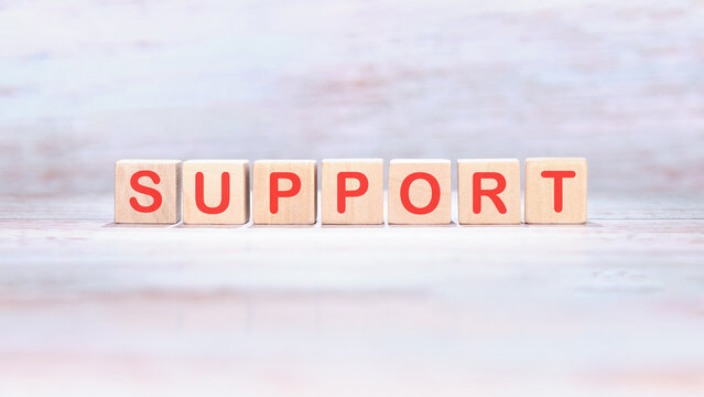 The concept word SUPPORT is made of wooden cubes on a light background. Business and SUPPORT concept. Copy space