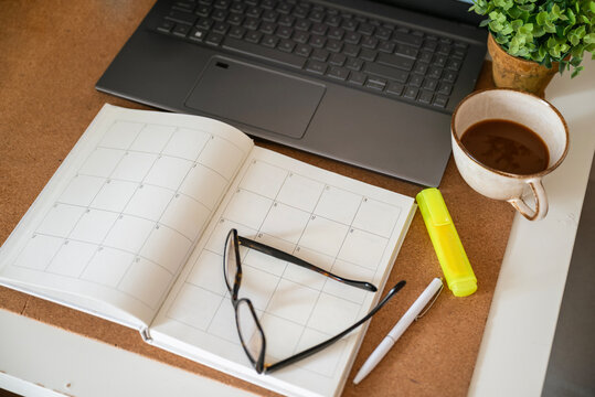 Notebook planner on a desk with laptop and coffee cup 
