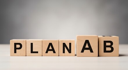 Wooden blocks spelling out plan a b in a row on a white surface