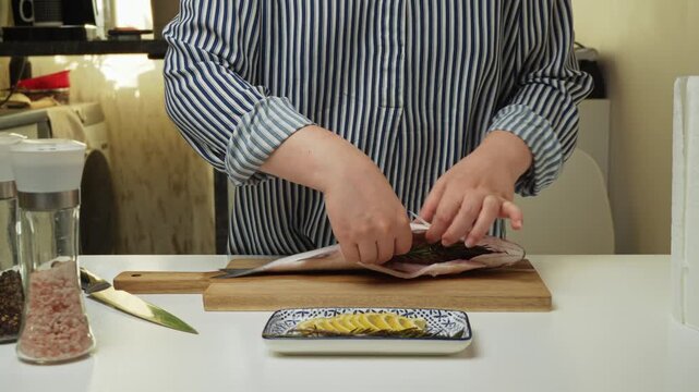 Female hands preparing the sea bass fish for cooking at home kitchen. Concepts of healthy eating and seafood
