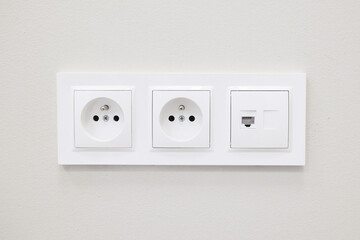 Triple wall socket installation. White electrical outlets on clean wall. Modern home interior power connection. Energy supply and electricity system background. Safe technology equipment at home.