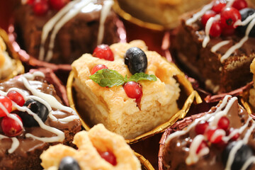 Sweet cupcakes dessert closeup. Pastry with chocolate and berries topping. Fresh baked cake with fruits. Festive bakery food decoration. Delicious muffin for celebration and party.