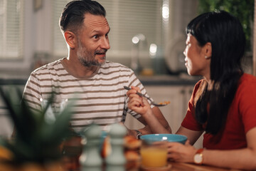 Couple enjoying breakfast and conversation in kitchen