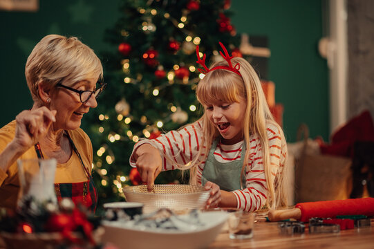 Grandmother and granddaughter baking christmas cookies together