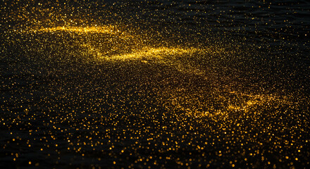 Sparkling golden glitter drifts across dark rippling water creating a magical, luxurious, and festive abstract background
