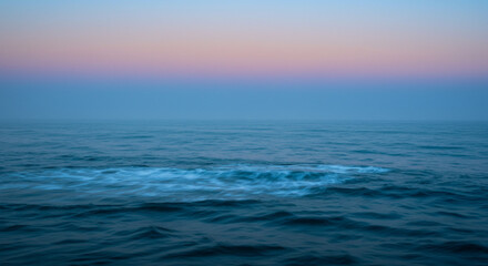 Obraz premium Serene ocean waves at dawn with soft pastel sky creating a peaceful, calming, and tranquil atmosphere for relaxation and meditation