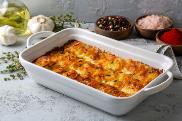 Potato gratin - graten (baked potatoes with cream and cheese) with rosemary and forks (Turkish name; Kremali patates)