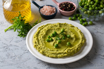 Bowl with tasty green pea hummus, green pea paste, lime and garlic