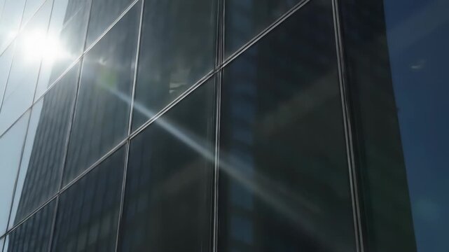 Modern Glass Skyscraper Reflecting Bright Sunlight Creating Lens Flares On A Clear Day