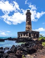 Obraz premium Ancient lighthouse on a volcanic shore, under a bright sky