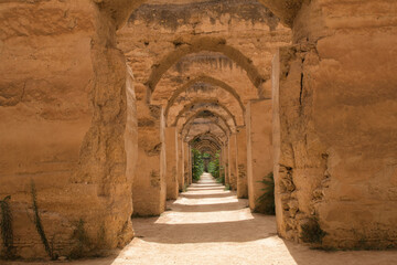 Old Ruined Arches in a Moroccan Kasbah - A view through an open wooden door of a series of old, crumbling arches in a kasbah or ancient fortress in Morocco.