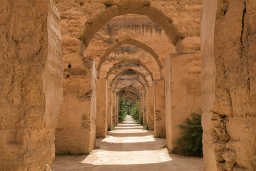 Old Ruined Arches in a Moroccan Kasbah - A view through an open wooden door of a series of old, crumbling arches in a kasbah or ancient fortress in Morocco.