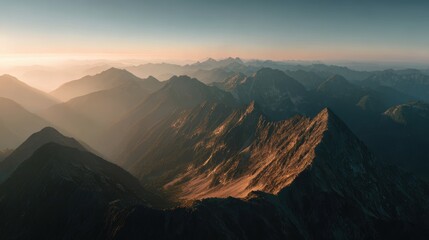 Majestic Mountain Vista: A breathtaking panorama of rugged mountain peaks basks in the golden hues of sunrise, a landscape of unparalleled grandeur and natural beauty.