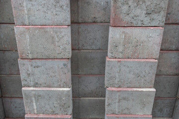Stack of gray and red concrete bricks for construction industry, building materials background, masonry texture concept and architecture design