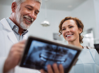 Dental consultation brings smiles as a patient reviews her x-ray with a dentist in a modern clinic setting Generative AI