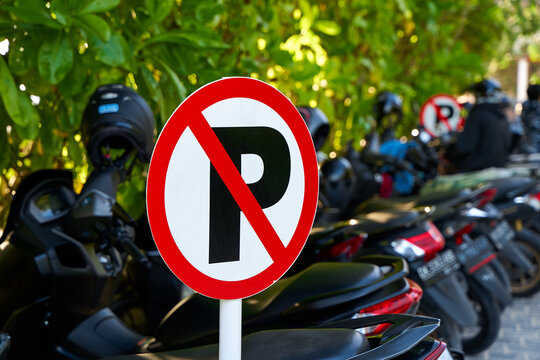 Warning sign - parking is prohibited. Full motorcycle parking near a no parking sign.