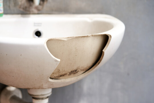 An old dirty broken ceramic sink in the cafeteria outside.