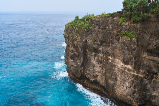 Cinematic aerial landscape shots of the beautiful island of Nusa Penida. Huge cliffs by the shoreline and hidden dream beaches with clear water and foaming wave.