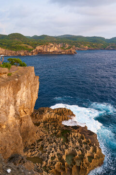 Cinematic aerial landscape shots of the beautiful island of Nusa Penida. Huge cliffs by the shoreline and hidden dream beaches with clear water and foaming wave.