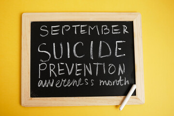 suicide inscription "September suicide prevention month" in chalk on a black chalk board