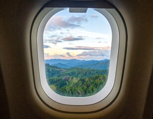 Airplane window view of mountain landscape at sunset