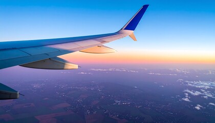 Fototapeta premium Airplane wing view of sunrise over landscape