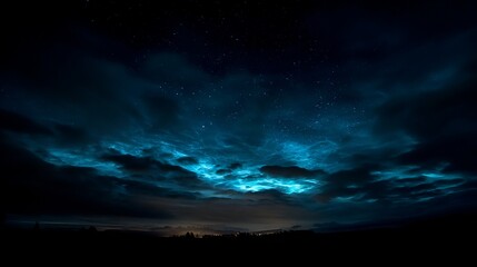 Stunning celestial panorama showcases vibrant turquoise clouds illuminated by distant stars and a faint glow over a silhouetted landscape at night