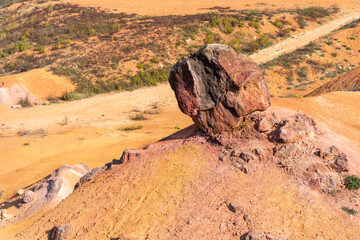 Fototapeta premium Eroded bauxite rock formation with bright orange colors in an abandoned bauxite mine