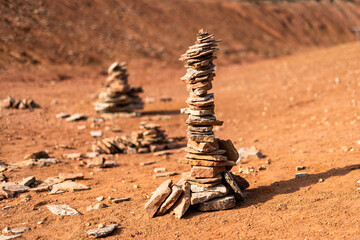 Stones stacked by hikers in a bright orange abandoned bauxite mine