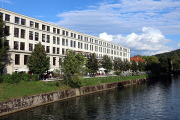 Langes wei&szlig;es Geb&auml;ude an der Ljubljanica durch Ljubljana
