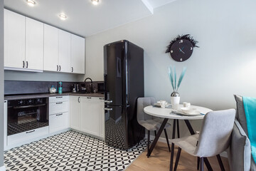 Stylish kitchen design in a minimalist apartment with elegant black and white decor and functional layout.