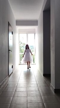 A girl in a white dress and a veil, the image of a scary bride, a zombie,walks around the house, on Halloween