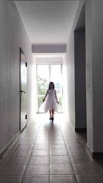 A girl in a white dress and a veil, the image of a scary bride, a zombie,walks around the house, on Halloween