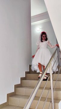 A girl in a white dress and a veil, the image of a scary bride, a zombie,walks around the house, on Halloween