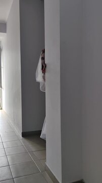 A girl in a white dress and a veil, the image of a scary bride, a zombie,walks around the house, on Halloween
