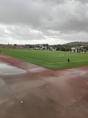 Fototapeta premium Empty football field after rain with cloudy sky